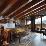 Elegant alpine suite at Guarda Golf Hotel & Residences featuring wooden beams, mountain views, and cozy luxury decor.